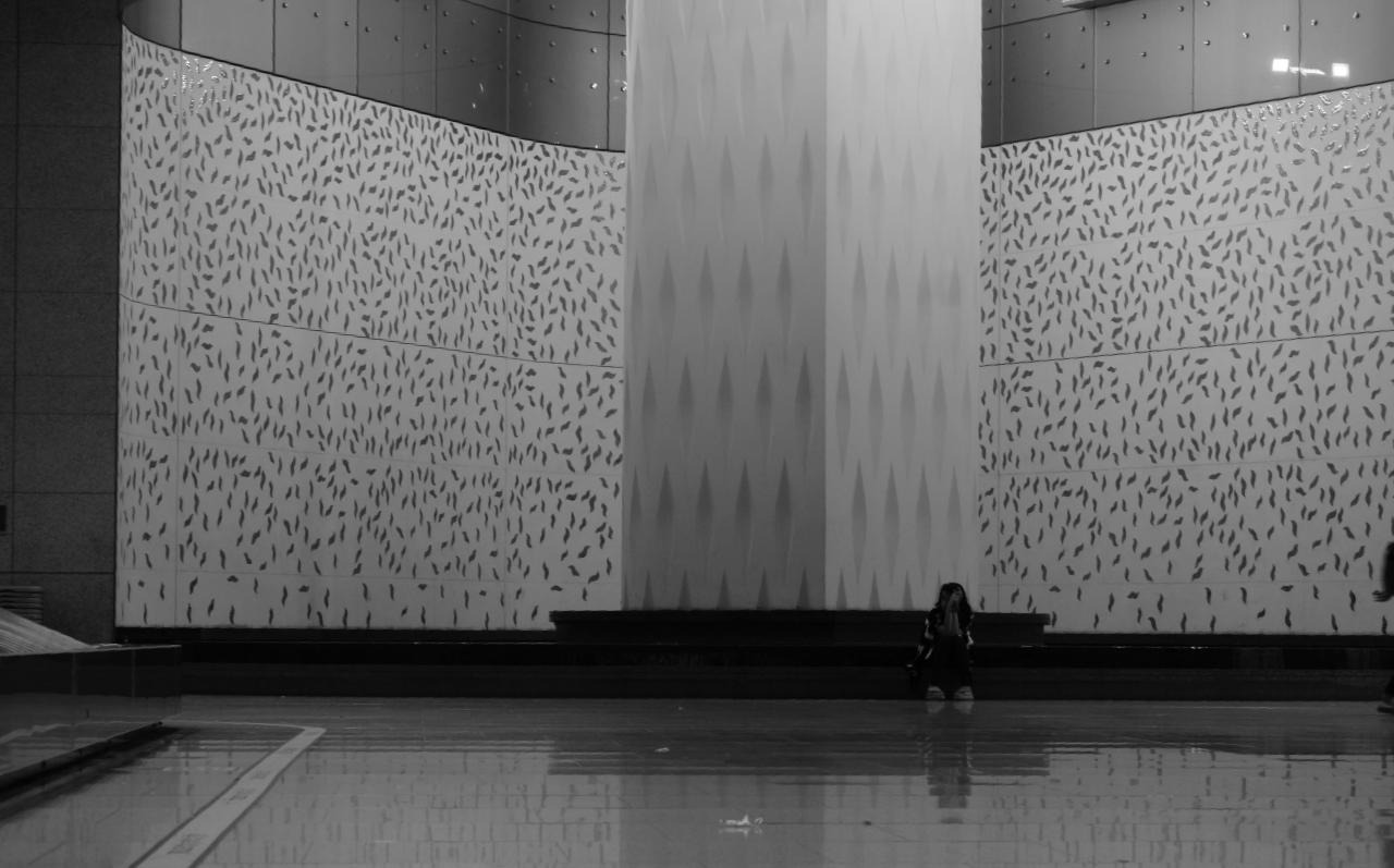 Lone figure against massive patterned walls at Bombay airport